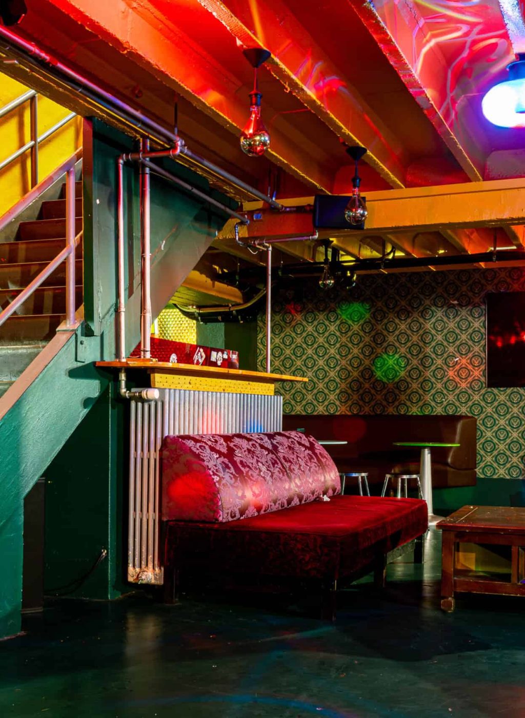 Bright nightclub scene with colorful lighting, cozy seating, and a lively atmosphere for nightlife e.